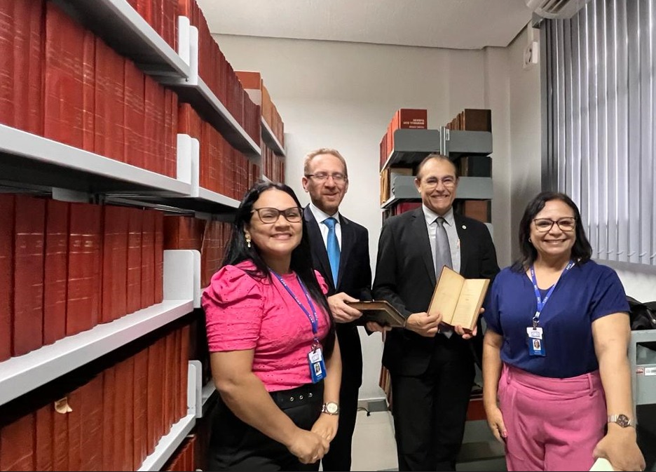 foto colorida de  juízes Carlos Böttcher do Tribunal de Justiça de São Paulo (TJSP) e membro do Comitê do Programa Nacional de Gestão Documental e Memória do Poder Judiciário (Proname/CNJ) e Claudemiro Avelino do Tribunal de Justiça do Alagoas (CMC/TJAL) e curador do Centro de Cultura e Memória do Poder Judiciário de Alagoas. na bibliotaca