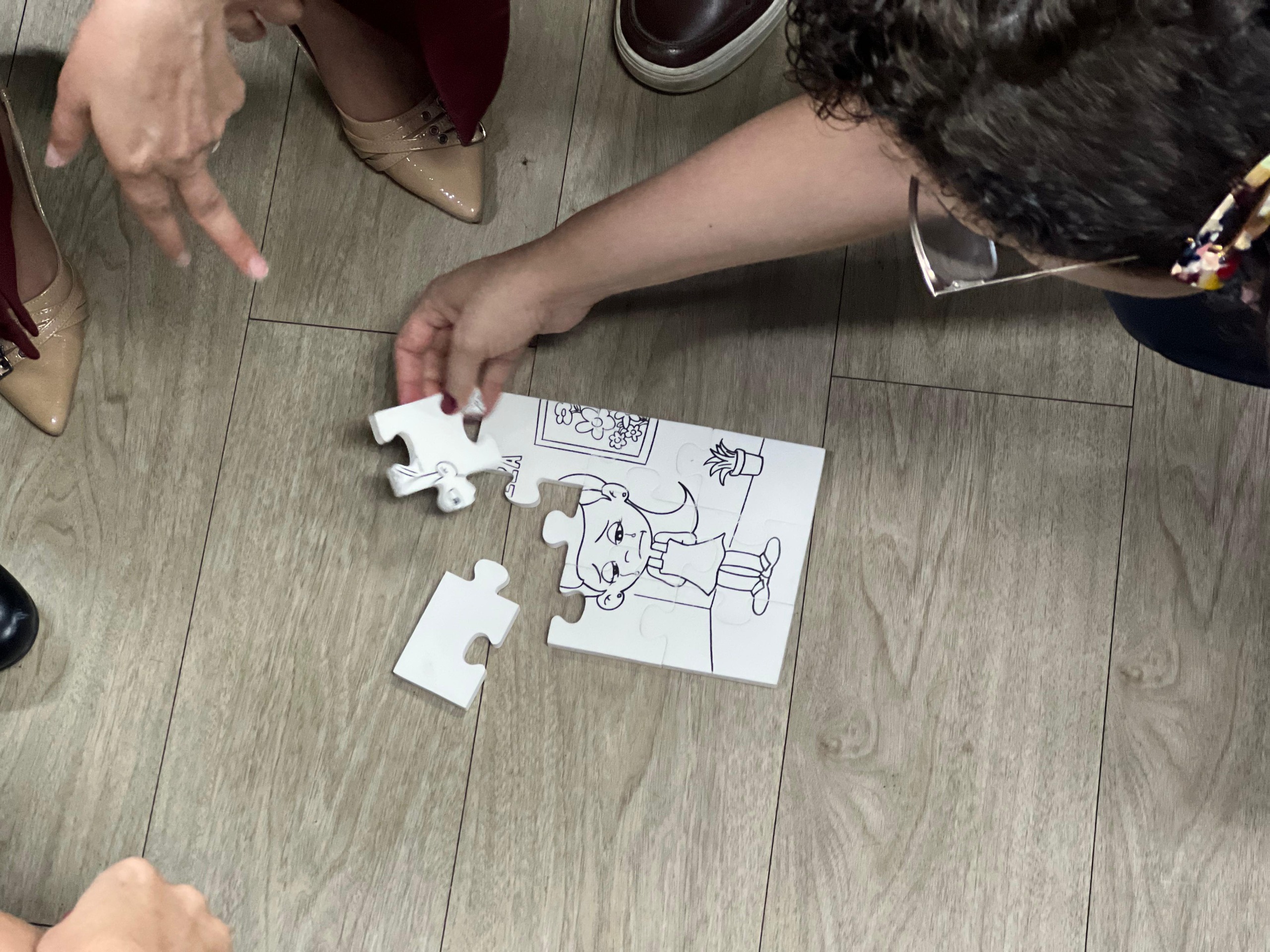 FOTO COLORIDA D EUM QUEBRA CABEÇA COM UM DESENHO DE UMA BONECA SENDO MONTADO