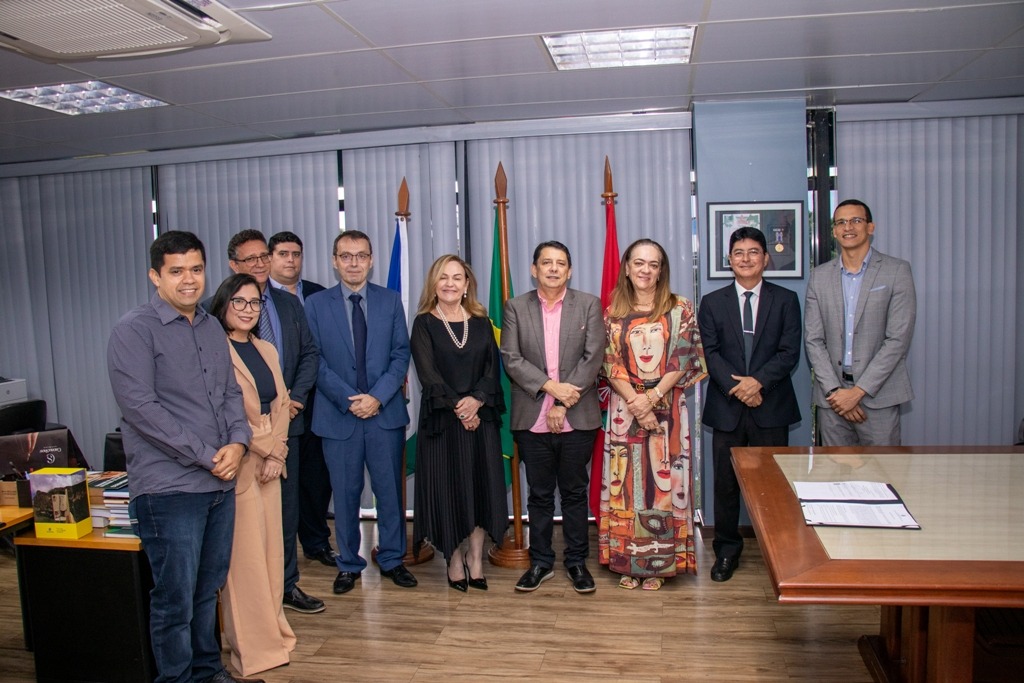 Foto colorida mostrando o presidente do TJRR, desembargador Jésus Nascimento, ao lado da equipe do Tribunal de Justiça do Acre (TJAC), liderada pela presidente do TJAC, desembargadora Regina Ferrari.