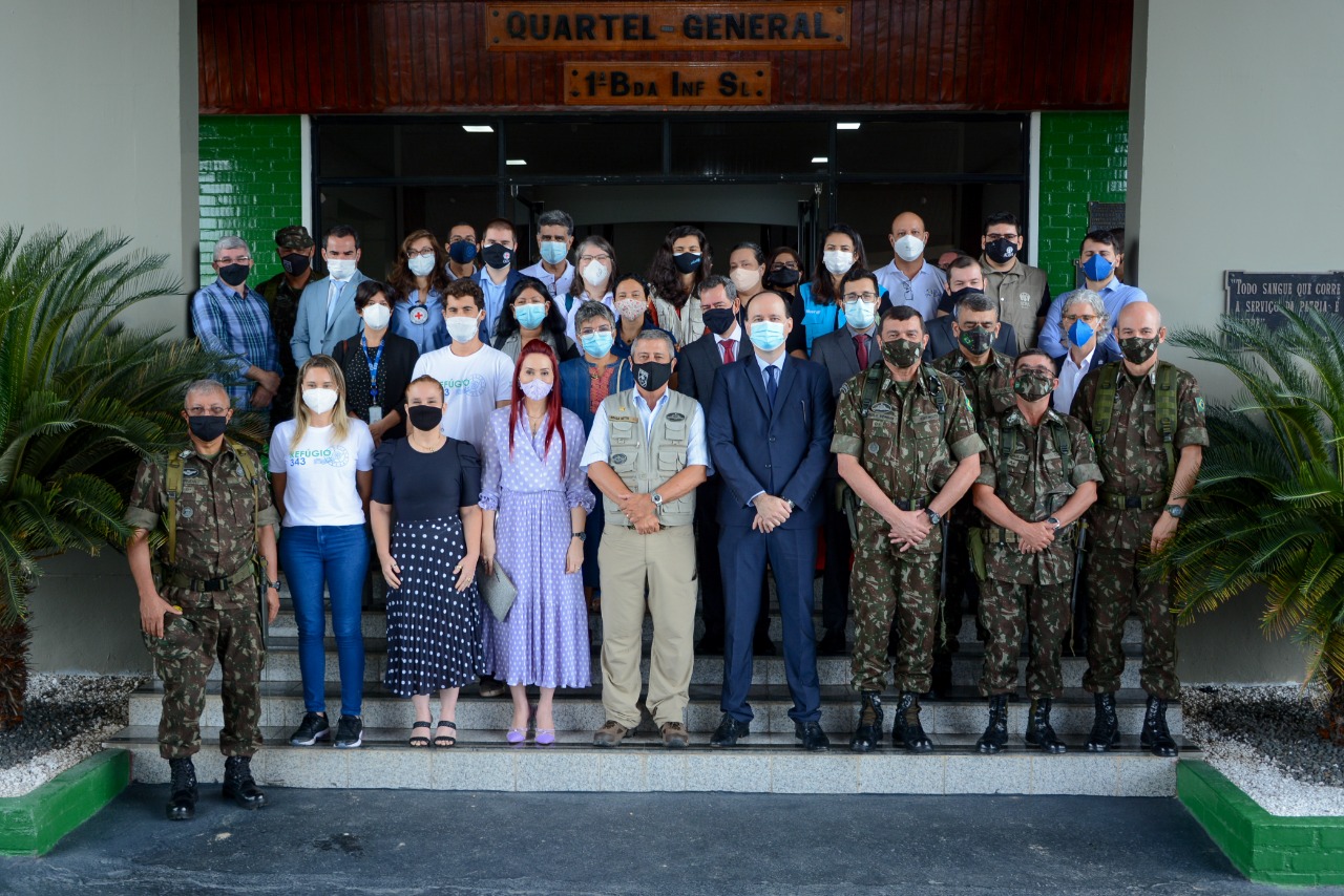 Presidente e servidores do Tribunal de Justiça, Ministro da Defesa e representantes do Exército, de pé posando para foto oficial. 