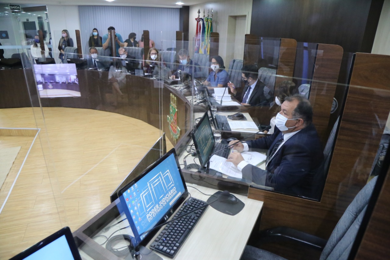 Servidores sentados em bancadas em reunião na sala de sessões do Palácio da Justiça.