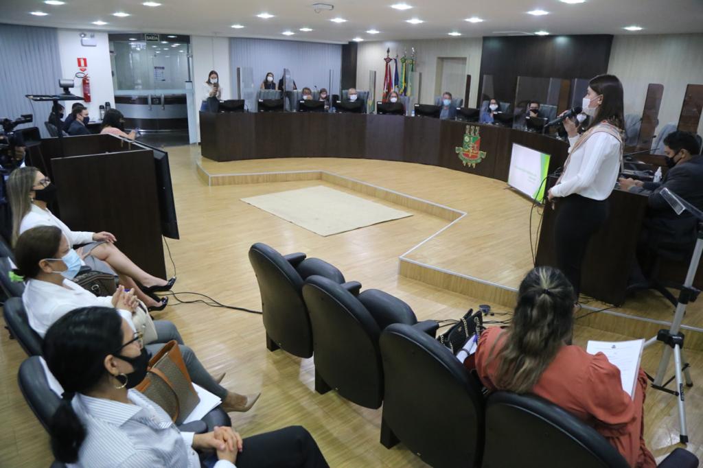 Foto da sala de sessões do Palácio da Justiça, mostrando a bancada e as pessoas sentadas em cadeiras da platéia.