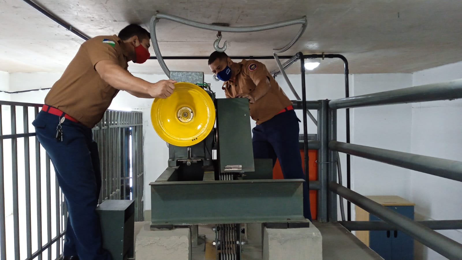 Bombeiros militares realizando testes e orientações preventivas na estação técnica de elevadores do TJRR.  