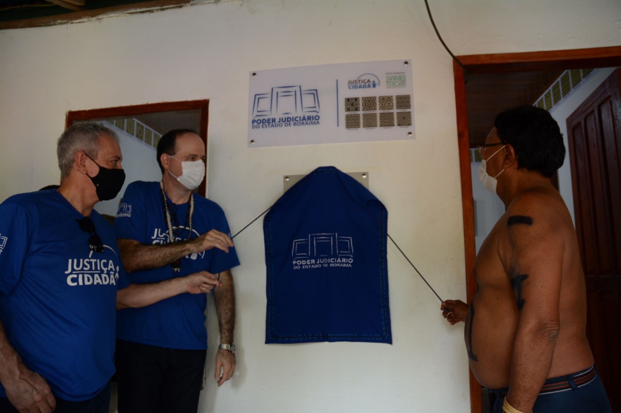 Presidente do TJRR, Desembargador Cristóvão Suter, Líder da comunidade indígena, Mario Parwe Atroari e Desembargador Almiro José Mello Padilha na placa de inauguração do Posto avançado de atendimento judiciário na Comunidade Indígena Waimiri-Atroari.