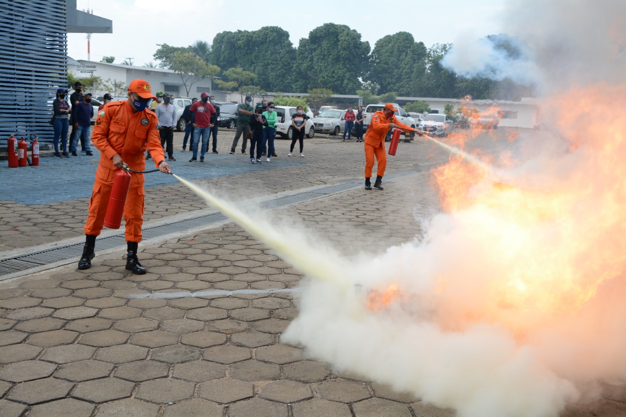 Bombeiro demonstrando como apagar um principio de incêndio 