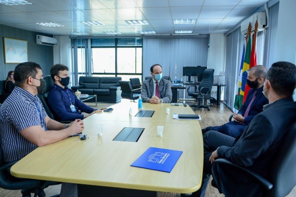 Desembargador Cristóvão Suter e representantes da Associação dos Analistas Judiciários de Roraima (Anjur) sentados ao redor de uma mesa de reuniões.