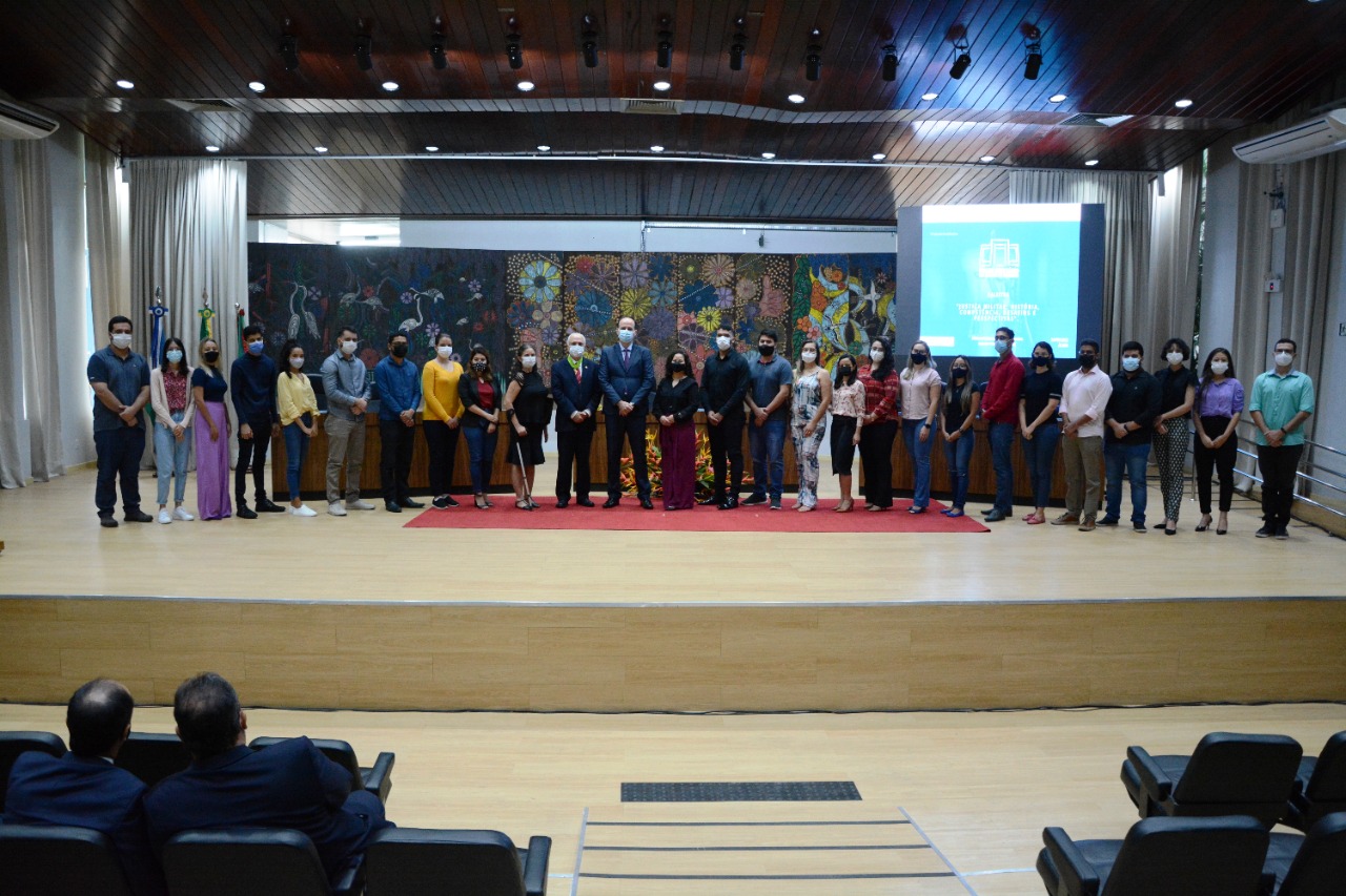 foto colorida mostra autoridades do poder judiciário e militar de Roraima e Brasília com estudantes do programa Residência Judicial no auditório do Fórum Advogado Sobral Pinto.