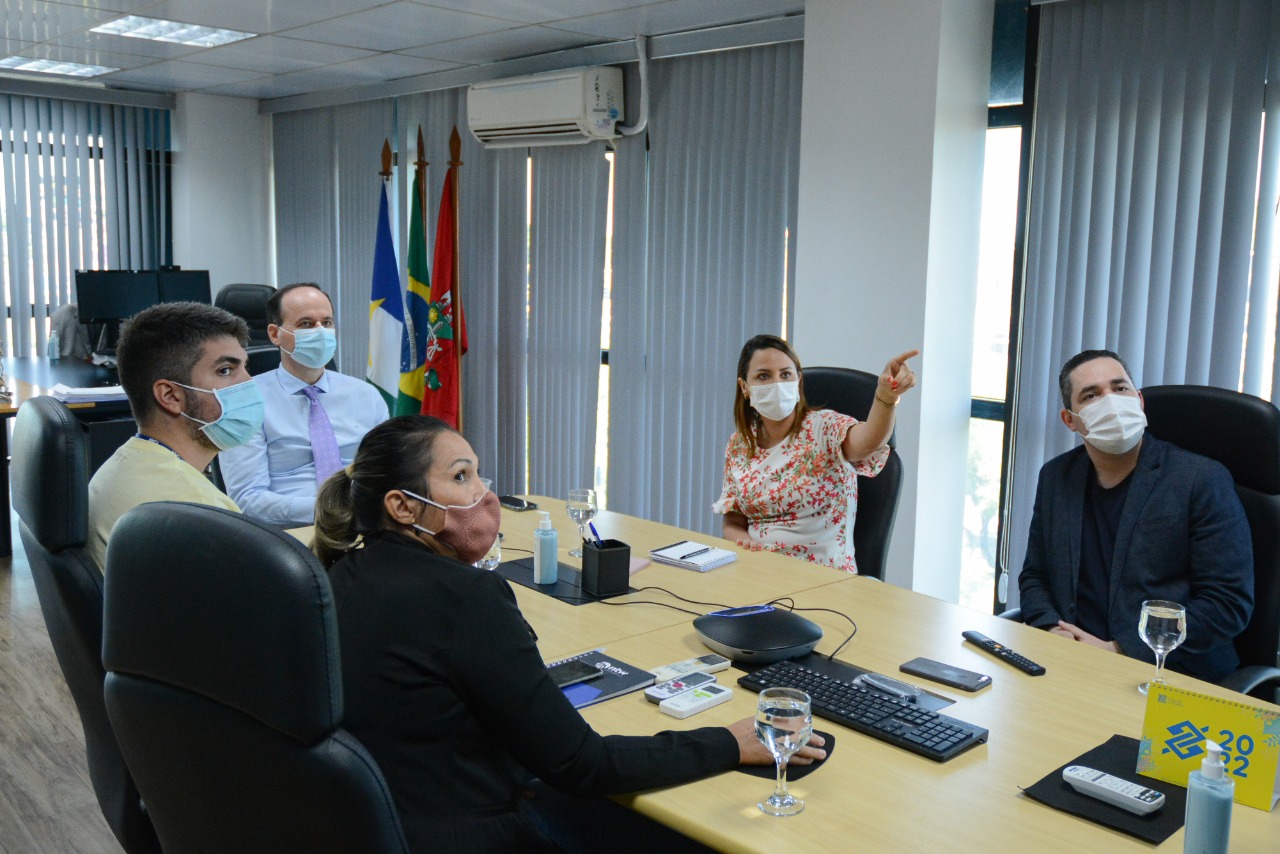 Servdores do TJRR, juntamente com o presidente do Poder Judiciario, desembargador Cristovão Suter, olhando para a TV