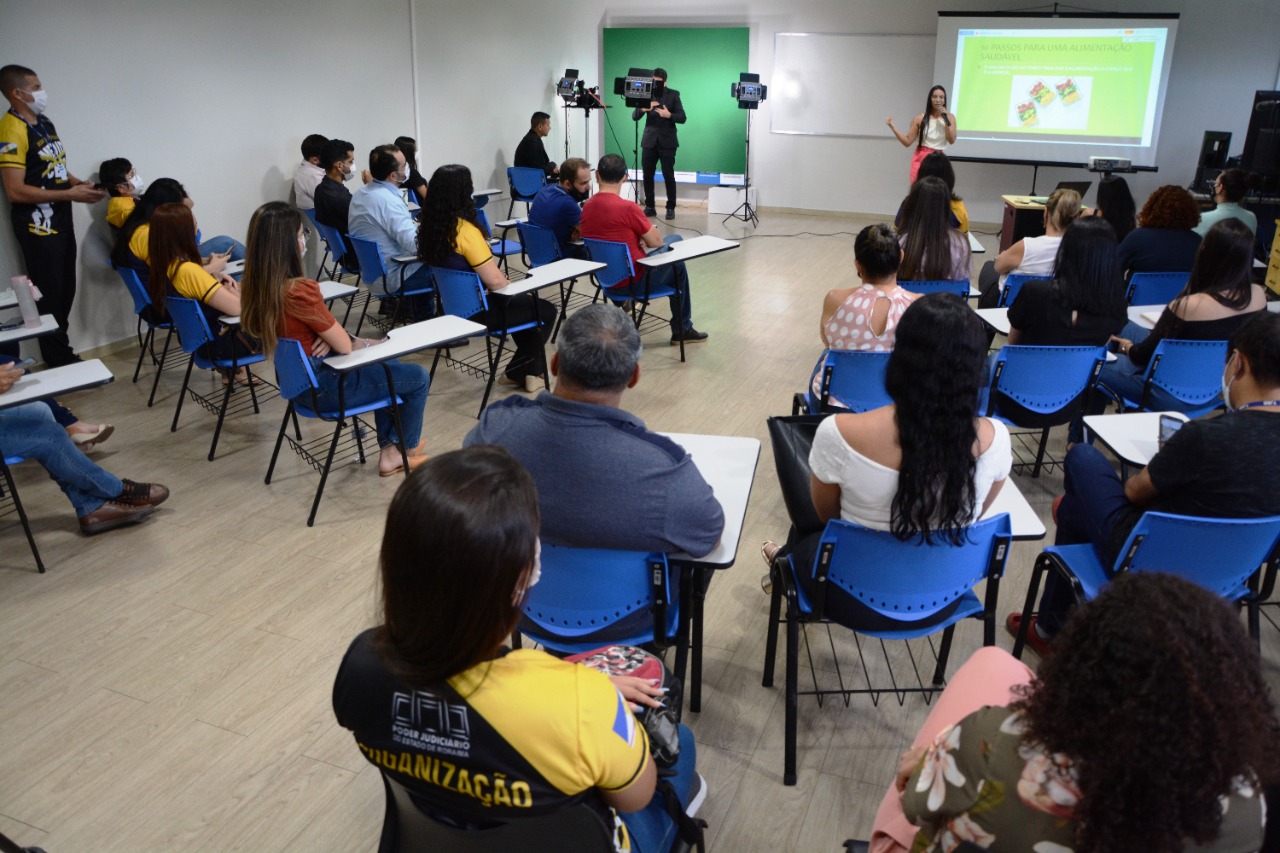 Imagem colorida contém pessoas reunidas e sentadas durante palestra sobre alimentação saudável, promovida pelo Centro Médico de Saúde e Qualidade de Vida do TJRR, com  palestrante em pé na frente de todos participantes