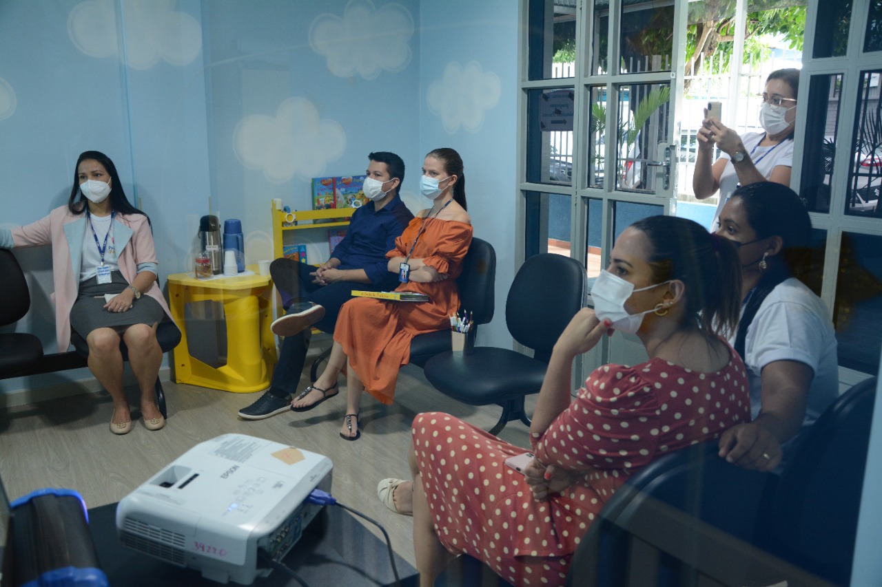 Foto colorida contém apenas participantes da oficina assistindo à palestra.