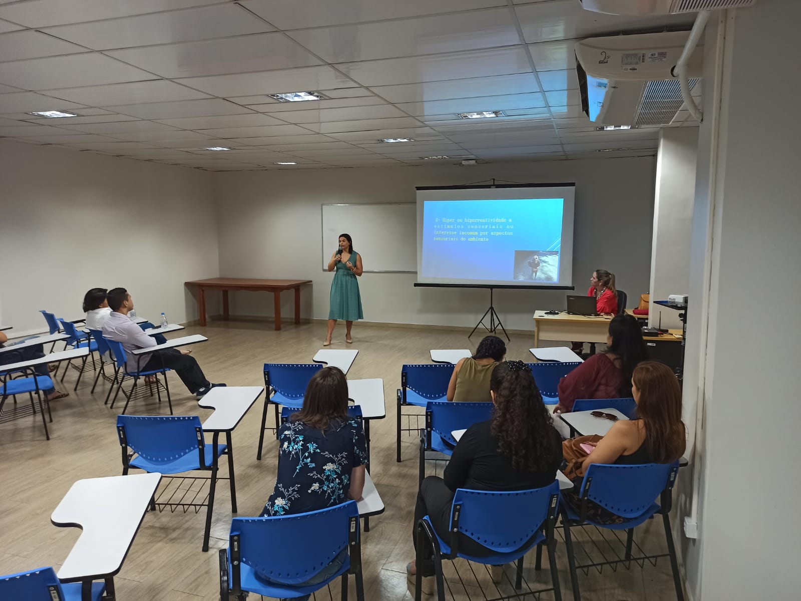 Imagem colorida contém servidores do TJRR, sentados  assistindo  palestra de conscientização sobre o autismo, organizado pelo Centro Médico e Qualidade de Vida, com palestrante em pé aos participantes. 