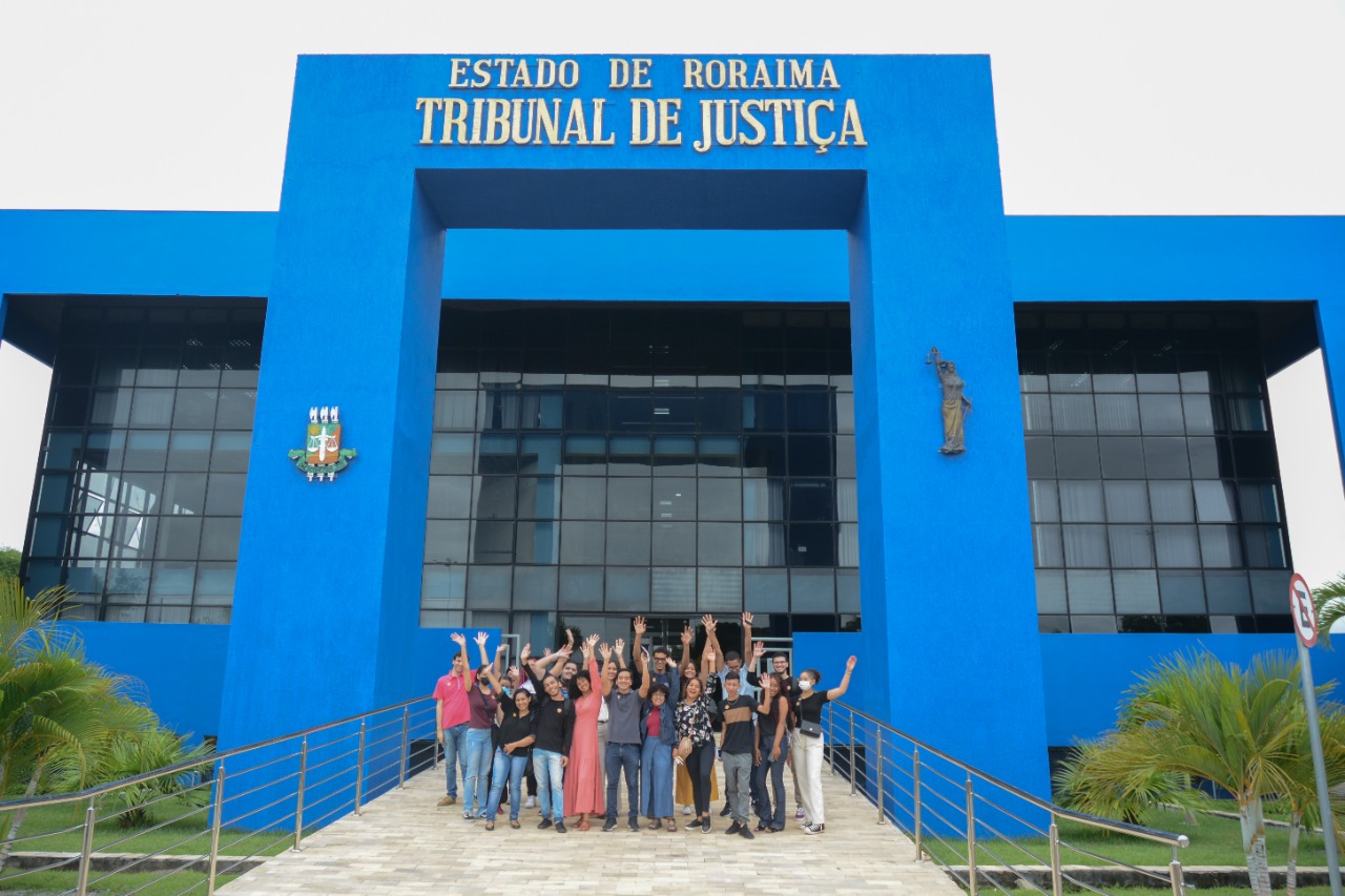  foto colorida mostra 17 estudantes de comunicação social da UFRR , posando para fotografia na entrada do Palácio da Justiça. 