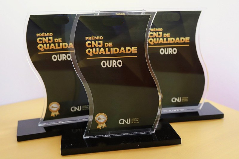 Imagem colorida mostra três troféus referente ao prêmio  do  CNJ 