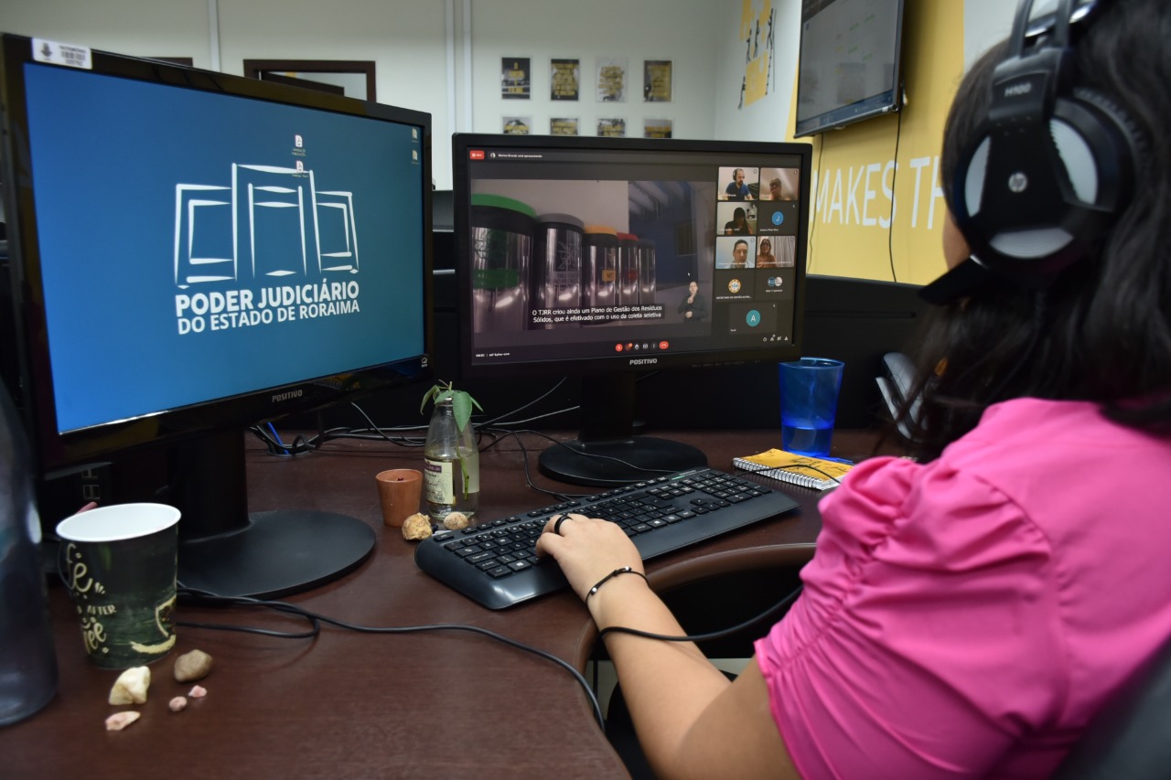 Imagem colorida contém servidora do TJRR assistindo o segundo Encontro de Boas Práticas entre os Tribunais Estaduais do Bioma Amazônico, de forma remota, na frente do computador. 