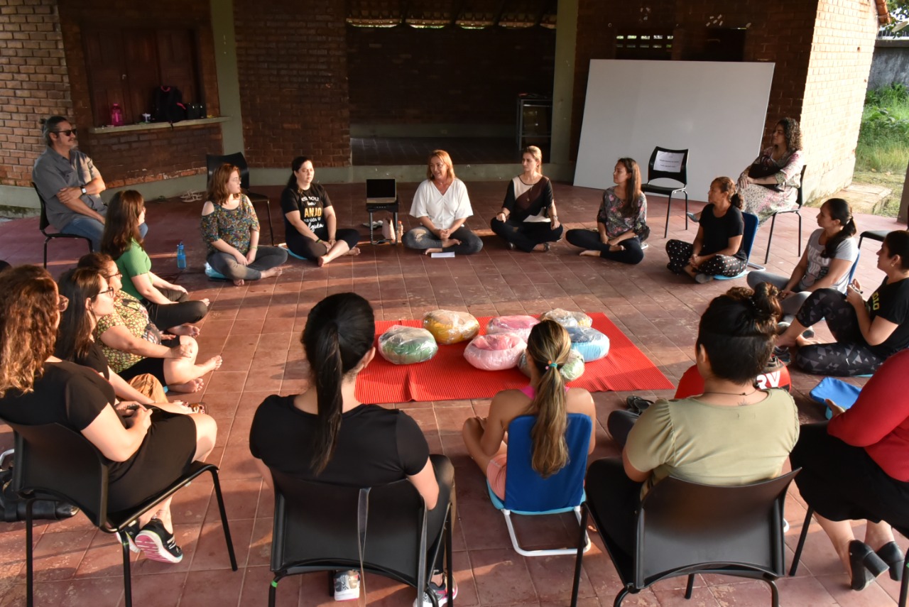 Imagem colorida de servidoras sentadas em posição de lótus em círculo, durante meditação em grupo, promovidas pelo Centro Médico e de Qualidade de Vida do Tribunal de Justiça de Roraima (TJRR).