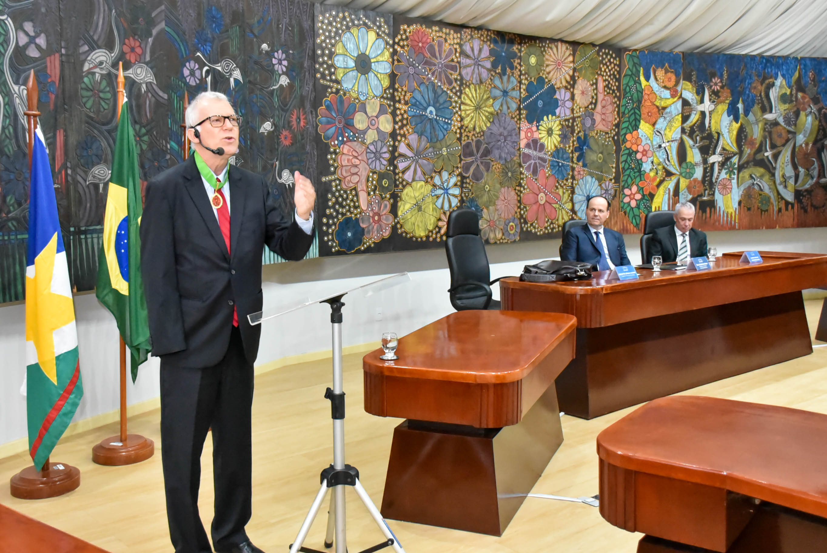 Imagem colorida contém o ministro do STJ, Sérgio Kukina, palestrando durante evento promovido pela EJURR, no Fórum Cível Advogado Sobral Pinto. Ao fundo sentados, encontram-se o Presidente do TJRR, desembargador Cristóvão Súter e o desembargador Almiro José Mello Padilha. 