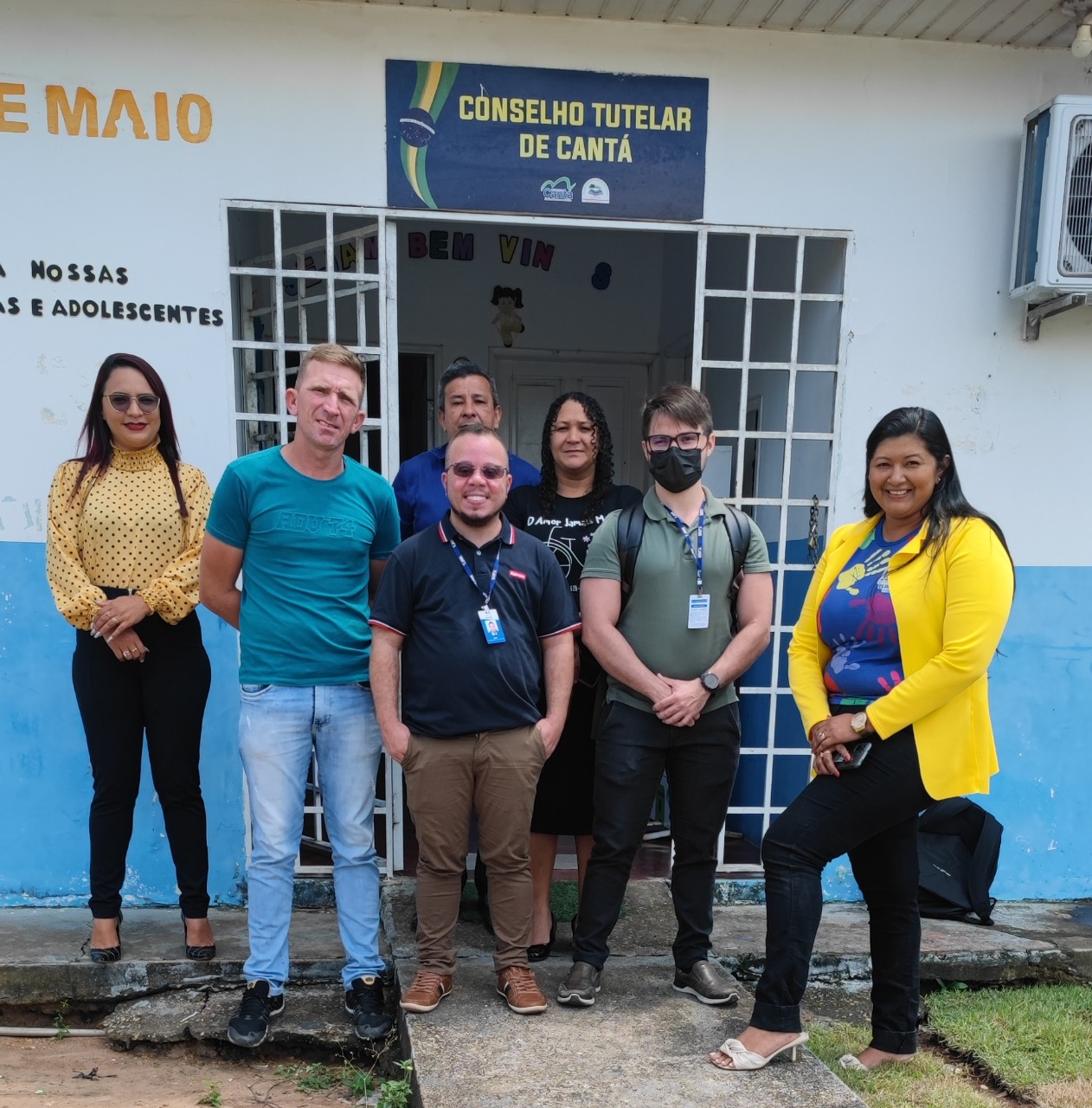 Imagem colorida com  7 pessoas em pé na entrada do conselho tutelar de cantá