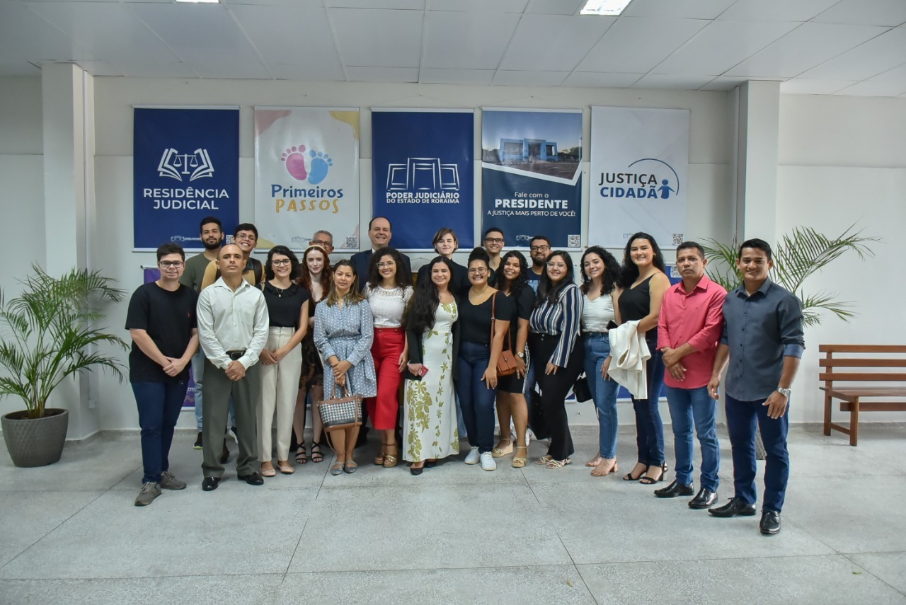  Imagem colorida em formato retangular , mostra o presidente do TJRR, desembargador Cristóvão Suter, ao lado de vinte acadêmicos de direito da Faculdade Cathedral.