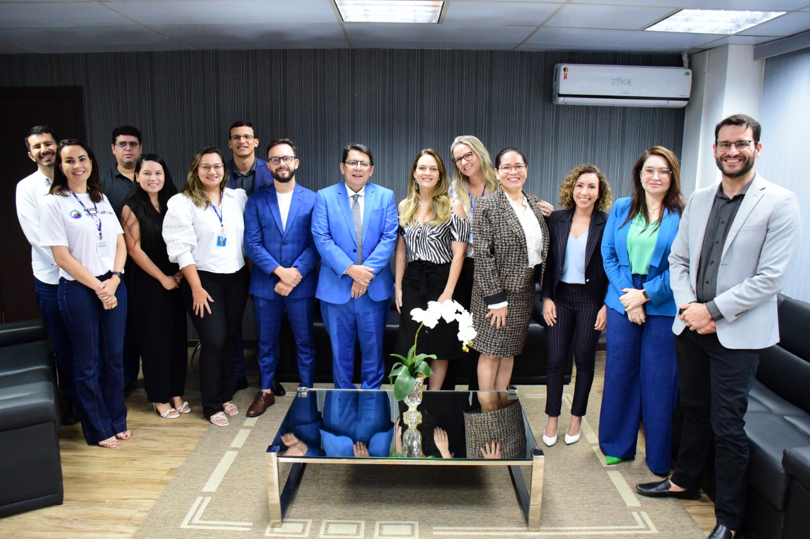  Imagem colorida mostra o presidente do TJRR, desembargador Jésus Nascimento, em pé posando para a foto ao lado de 13 servidores, entre os quais estão os  secretários e coordenadores da instituição.