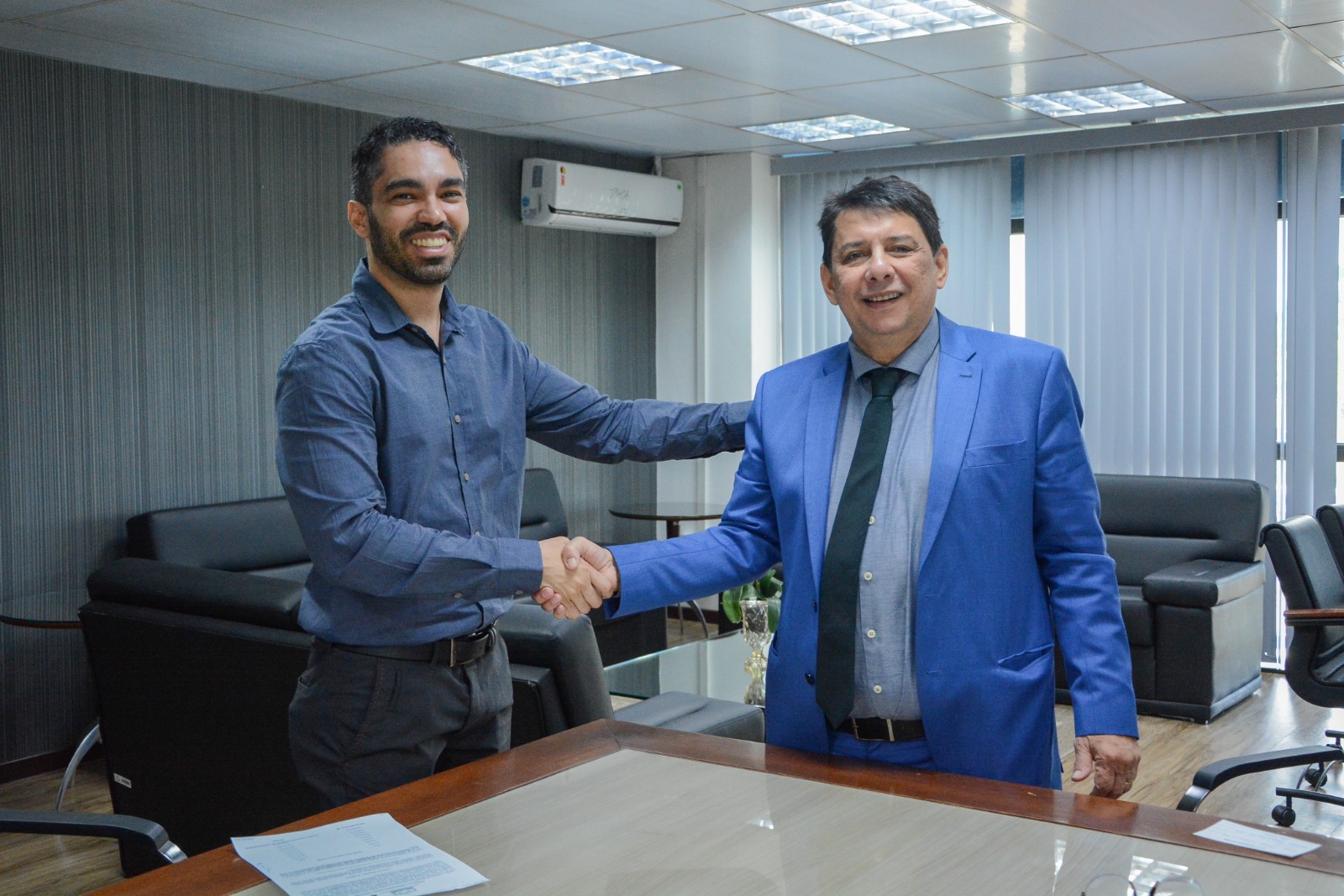 foto colorida do presidente do TJRR, desembargador Jésus Nascimento dando um aperto de mão no  presidente da FETEC, José Diego