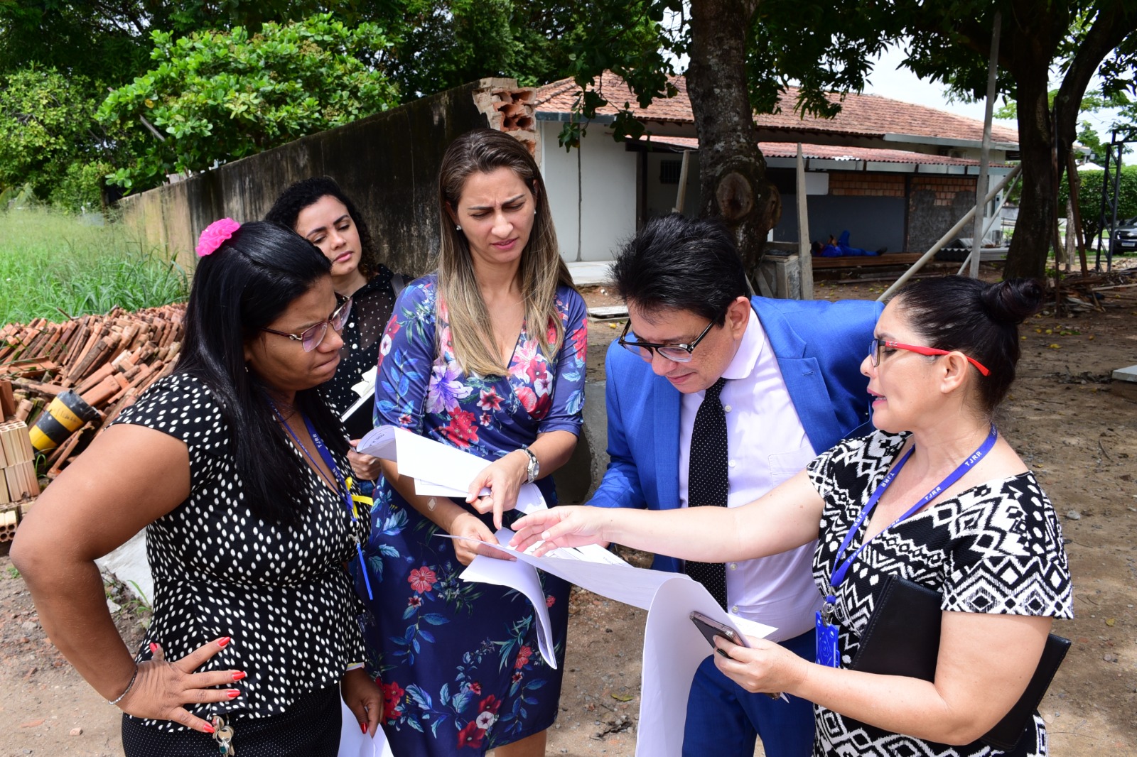 foto colorida do Presidente do TJRR, des Jésus Nascimento, junto com outras servidores olhando a planta da obra que está em andamento 