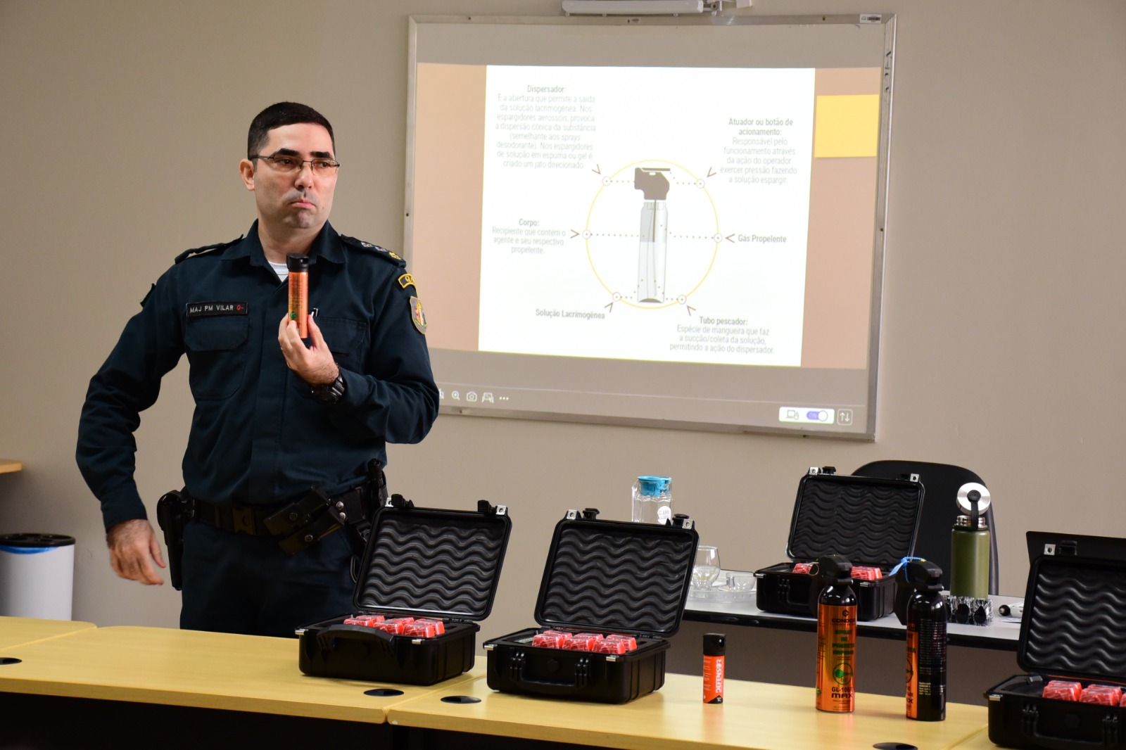 foto colorida d em policial segurando um spray de pimenta