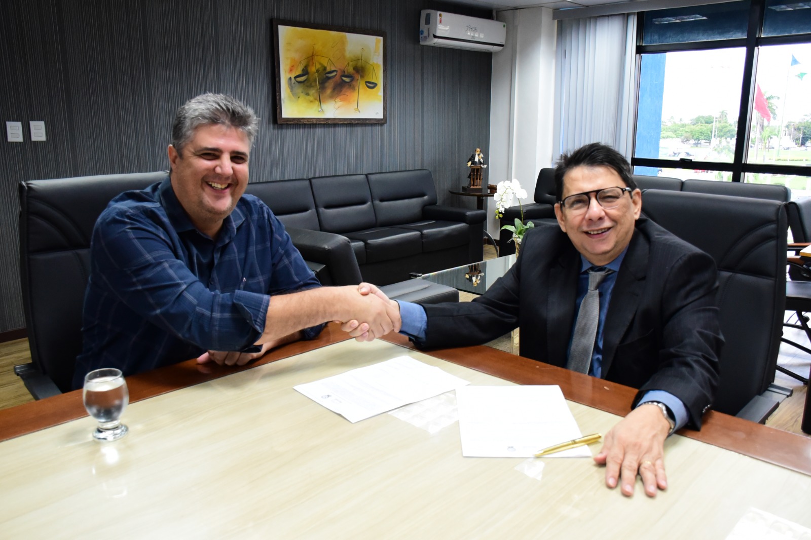 foto colorida do presidente do TJRR, desembargador Jésus Nascimento junto com  o prefeito de Bonfim, Joner Chagas olhando para a camera e fazendo aperto de mão