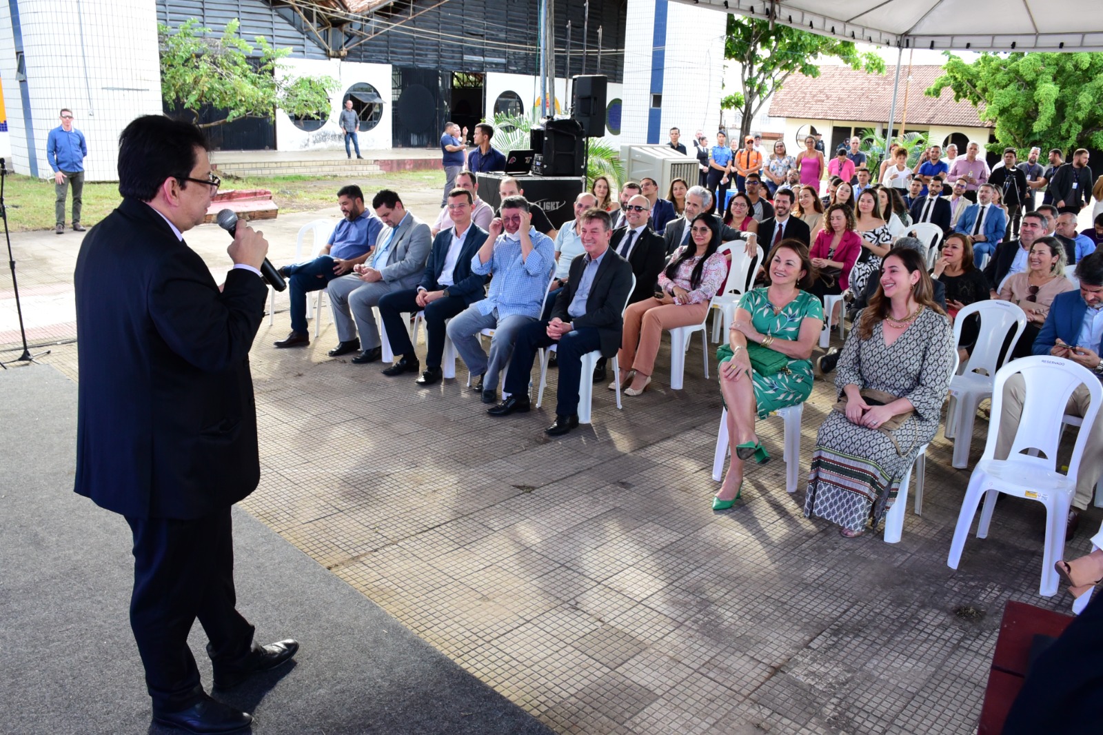 foto colorida do Presidente do TJRR, Desembargador Jésus Nascimento falando ao microfone para os presentes para autoridades e servidores que estão sentados abiaxo de uma tenda no Palácio Latife Salomão