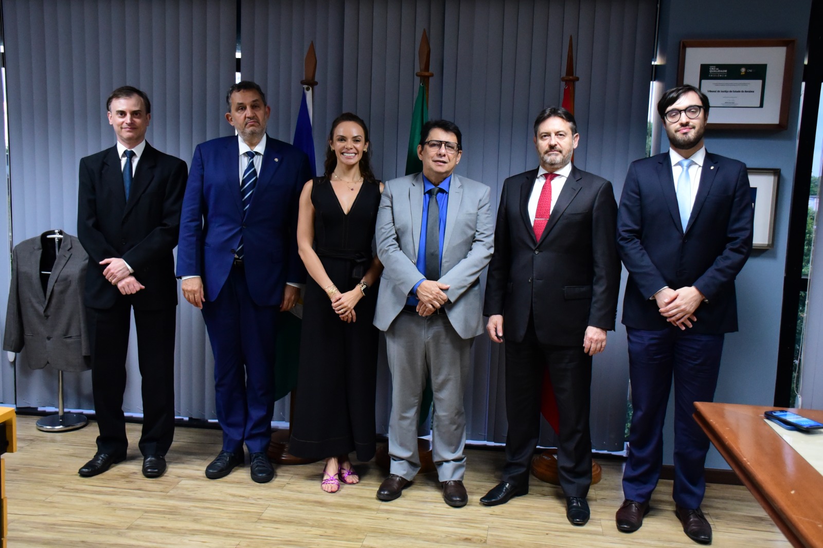 Foto colorida mostra o presidente do TJRR, desembargador Jésus Nascimento, posando para foto juntamente ao o procurador-Geral de Justiça, Fábio Stica,  o Vice-Presidente do Conselho Superior do MPT, Sebastião Vieira Caixeta, a Procuradora-Chefe da PRT11ª Região, Alzira Melo Costa, o Coordenador da Procuradoria do Trabalho em Boa Vista, Pedro Henrique Godinho Faccioli e o Procurador do Trabalho, Cássio Calvilani Dalla-Déa. Todos estão de pé, na sala da presidência do TJRR.