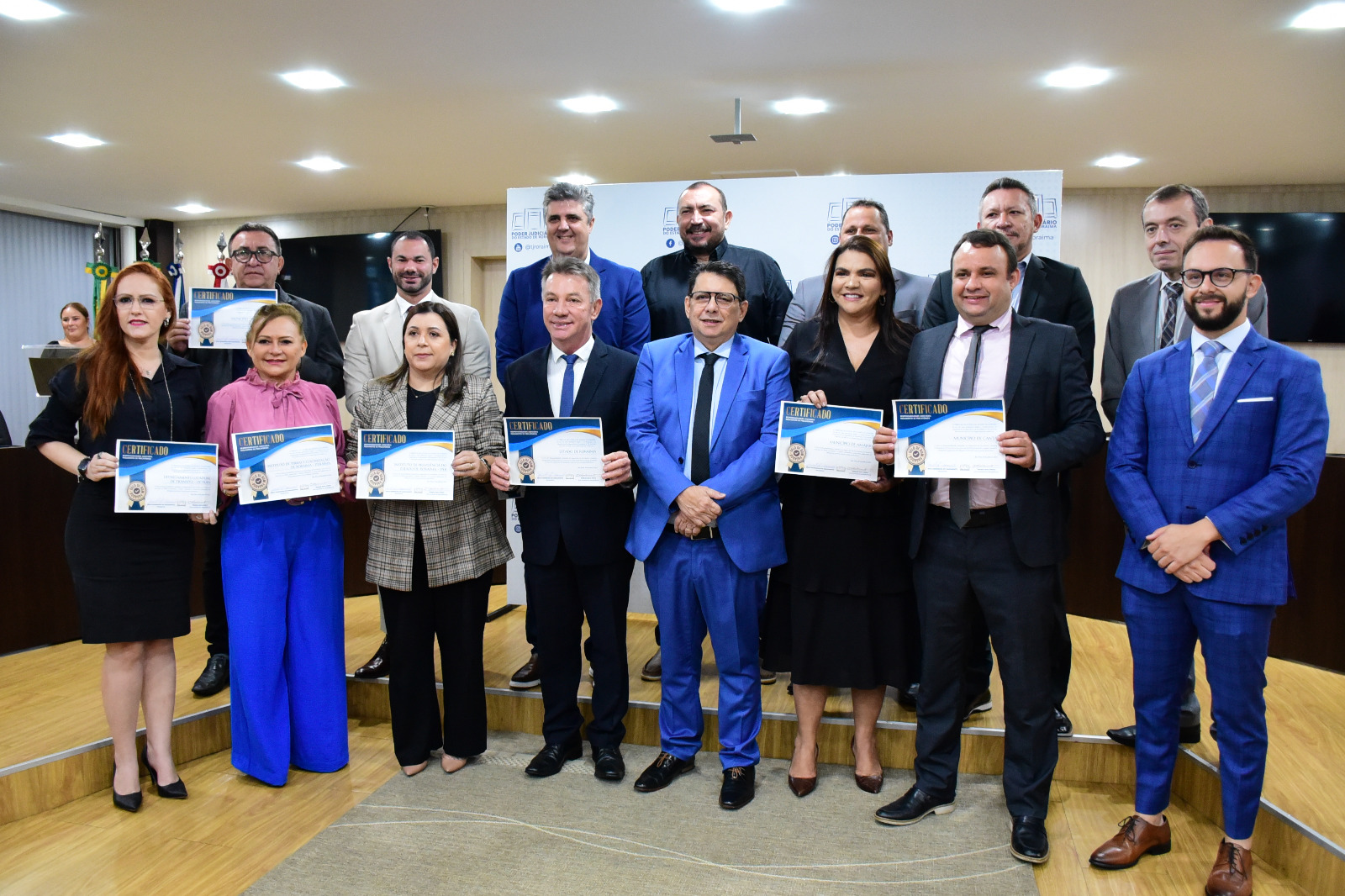foto colorida de servidores com o certificado do selo bom pagador pousando para a foto. Na foto tem o presidente do TJRR e o governador Antônio denarium