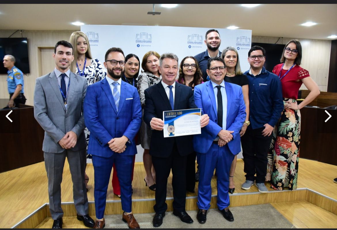 foto colorida de servidores com o certificado do selo bom pagador pousando para a foto. Na foto tem o presidente do TJRR e o governador Antônio denarium