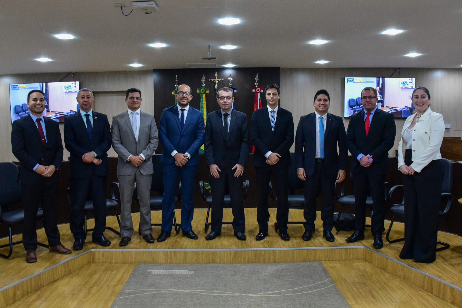 foto colorida mostra o secretário geral de gestão estratégica do TJRR, Igor Dourado, o presidente da OAB/RR, Edinaldo Vidal, o procurador adjunto da Procuradoria-Geral do Estado, Cláudio Belmino, o juiz Rodrigo Delgado, o desembargador Erick Linhares, o representante do Ministério Público de Roraima, o presidente da AMARR, juiz Marcelo Oliveira, o defensor público estadual, Frederico César e a juíza Rafaella Holanda. Todos estão de pé, posando para foto em frente à tribuna do Tribunal Pleno.