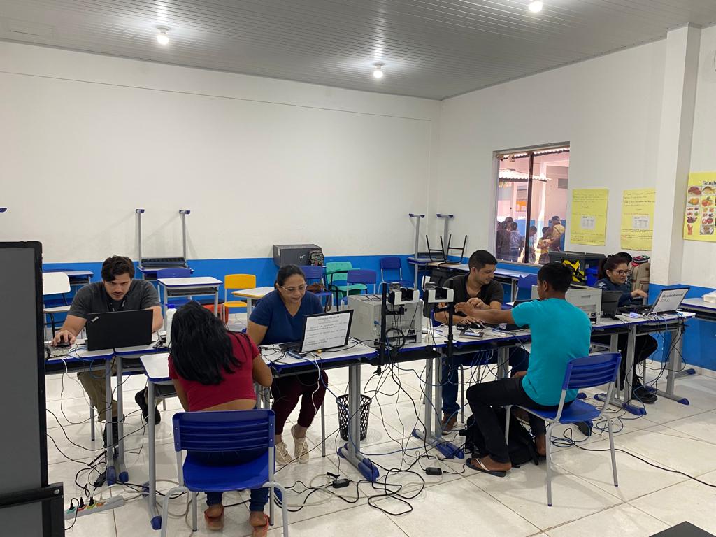 foto colorida de uma mesa com 4 funcionários realizando atendimentos