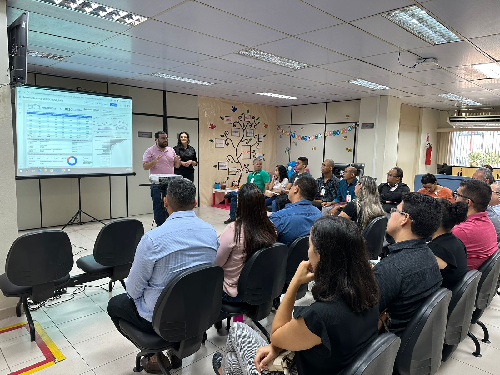 foto colorida da tuma sentada em direção ao slide e ao mediador da aula