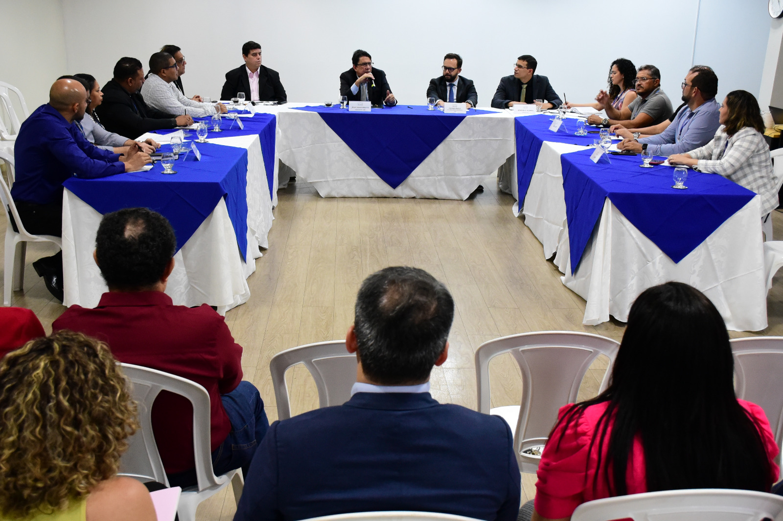foto colorida mostra o presidente do TJRR, desembargador Jésus Nascimento, sentado em frente a uma mesa posicionada em formato de “U”, falando ao microfone, para os representantes de sindicatos e associações de servidores do Poder Judiciário de Roraima. Ao lado do presidente estão o juiz auxiliar da presidência, Esdras Silva, o secretário geral, Henrique Tavares, o chefe da assessoria Jurídica da presidência, Alexandre Martins e a chefe de gabinete da presidência Jakelane Oliveira