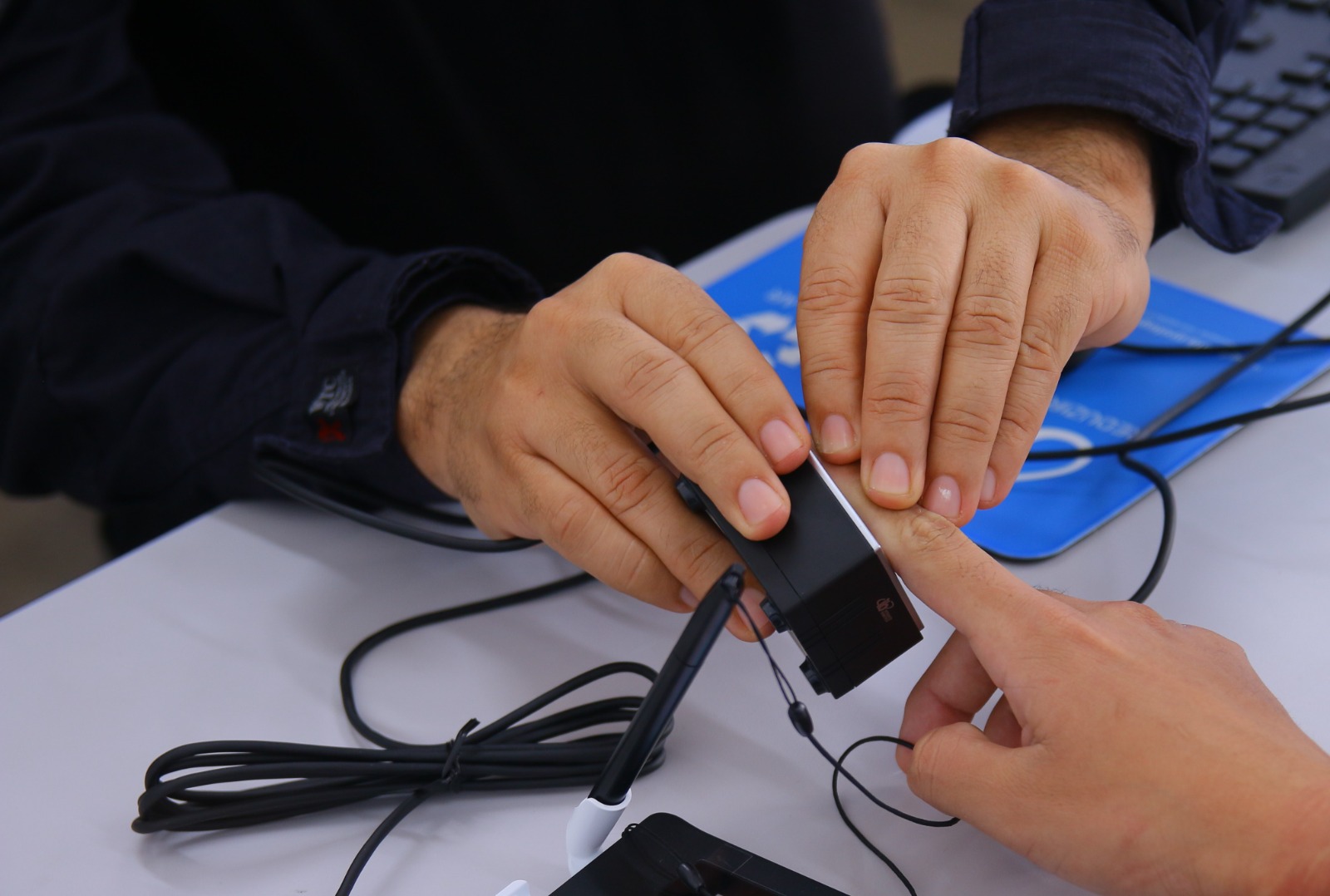 FOTO COLORIDA DE UMA PESSOAS COLETANDO A BIOMETRIA