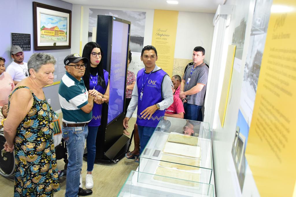 foto colorida da turma de idosos dentro do CMC observiando os acervos e sendo guiados pelo um historiador do cmc