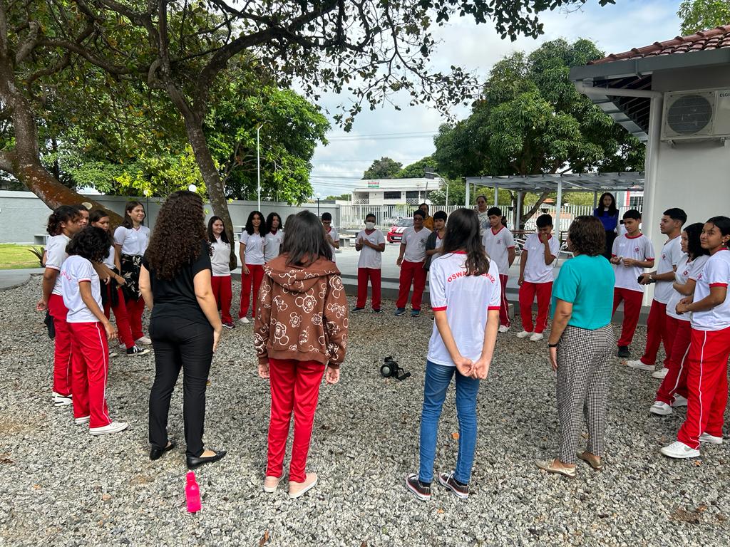 Alunos reunidos em um círculo conversando.