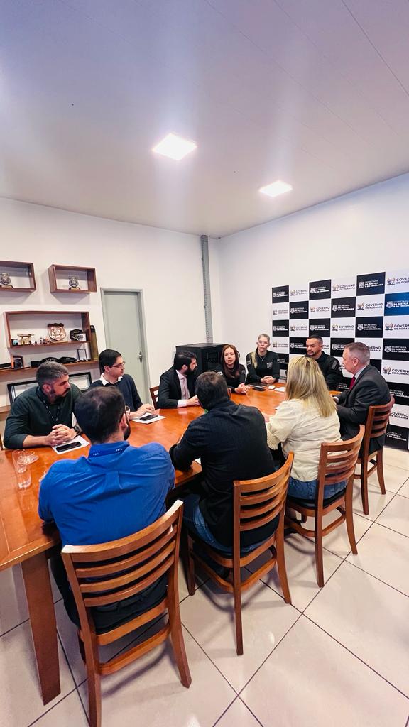  Foto mostra dez pessoas reunidas em uma mesa retangular durante reunião. A comitiva do TJRR, contendo sete integrantes do Judiciário,  o desembargador Almiro Padilha, supervisor do Grupo de Monitoramento do Sistema Carcerário – GMF, o juiz da Vara da Execução Penal, Daniel Amorim e os servidores do GMF Dagoberto Gonçalves, Débora Gomes e Jadson Costa, além do do secretário de tecnologia e informação do TJRR, Tiago Lobo e o servidor Gabriel Silveira. As outras três pessoas eram representantes da Sejuc, o secretário de justiça e cidadania, Hércules Pereira, a secretária adjunta, Michelly Vial e a diretora do Departamento Sistema Penitenciário, Fabiany Said. 