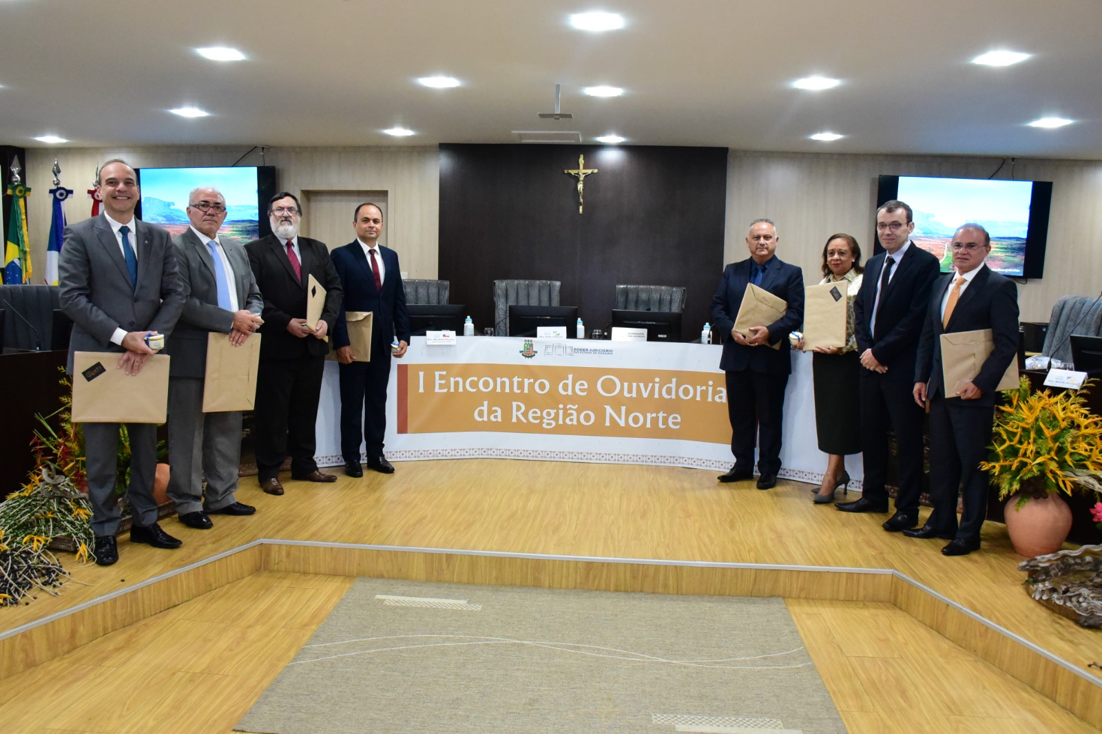 foto colorida com todos ouvidores reunidos em pé alinhados um ao lado dos outros pousando para a foto