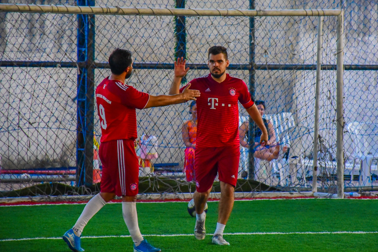 foto colorida de dois jogadores do time vermelho trocando saudações