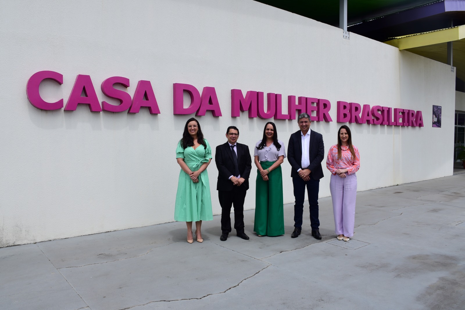 Foto colorida mostra cinco pessoas posando para fotografia, em frente a fachada escrita “Casa da Mulher Brasileira”. Na imagem, está o presidente do TJRR, desembargador Jésus Nascimento, ao lado do vice-governador, do Estado de Roraima, Edilson Damião Lima,a secretária da Setrabes, Tânia Soares, da juíza titular da Coordenadoria Estadual da Mulher em Situação de Violência Doméstica do TJRR, Suelen Márcia Alves e da promotora Lucimara campaner.