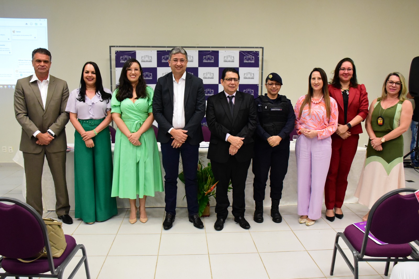 oto colorida mostra mostra nove pessoas posando para fotografia, na “Casa da Mulher Brasileira”. Na imagem, está o presidente do TJRR, desembargador Jésus Nascimento, ao lado do vice-governador, do Estado de Roraima, Edilson Damião Lima,a secretária da Setrabes, Tânia Soares, da juíza titular da Coordenadoria Estadual da Mulher em Situação de Violência Doméstica do TJRR, Suelen Márcia Alves, da promotora Lucimara campaner e mais quatro participantes