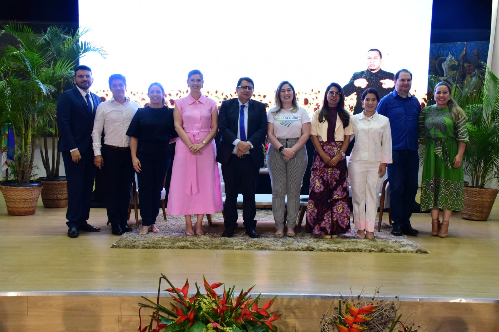 foto colorida no palco do auditório reunindo  alguns participantes que estiveram presente na semana do solo seguro