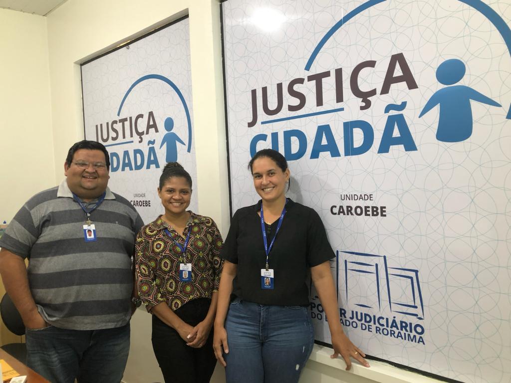 foto colorida de servidores do TJRR pousando para foto na frente de uma janela que tem um adesivo da Justiça Cidadã