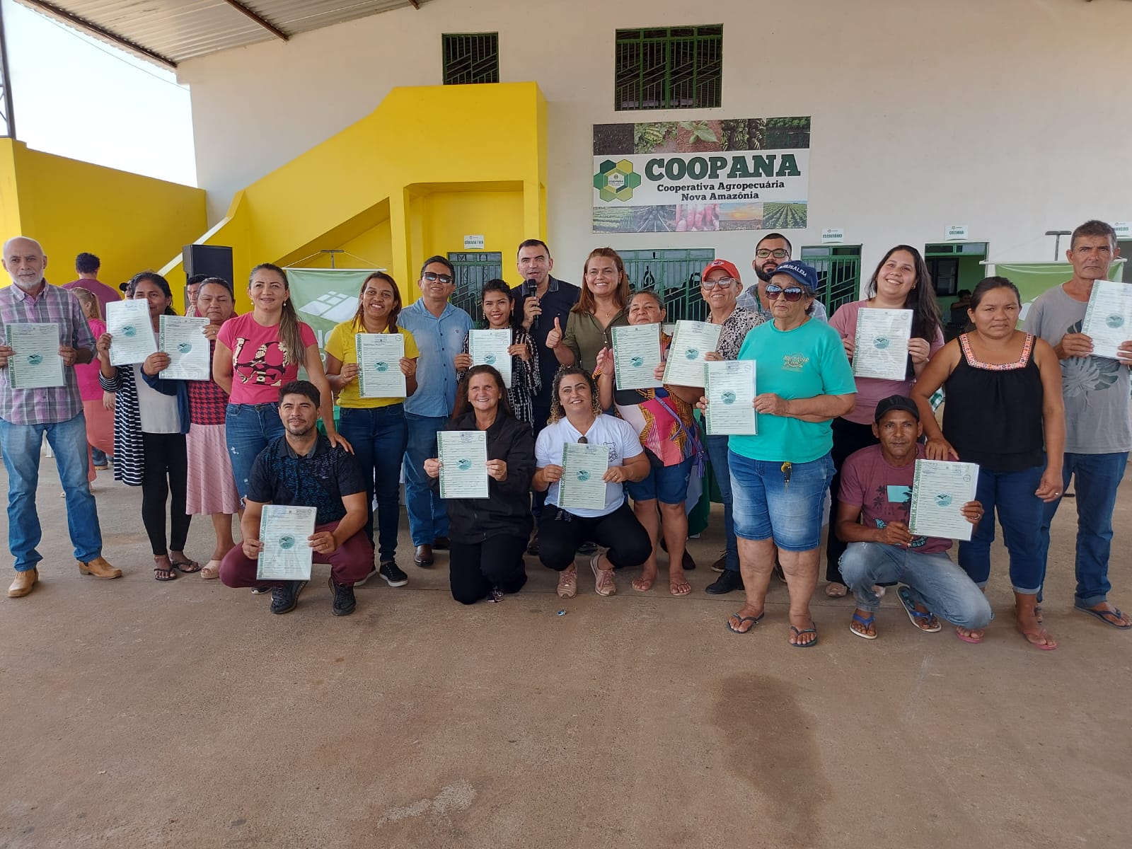 foto colorida de um grupos de pessoas pousando para a foto com os seus títulos definitivos na mão 