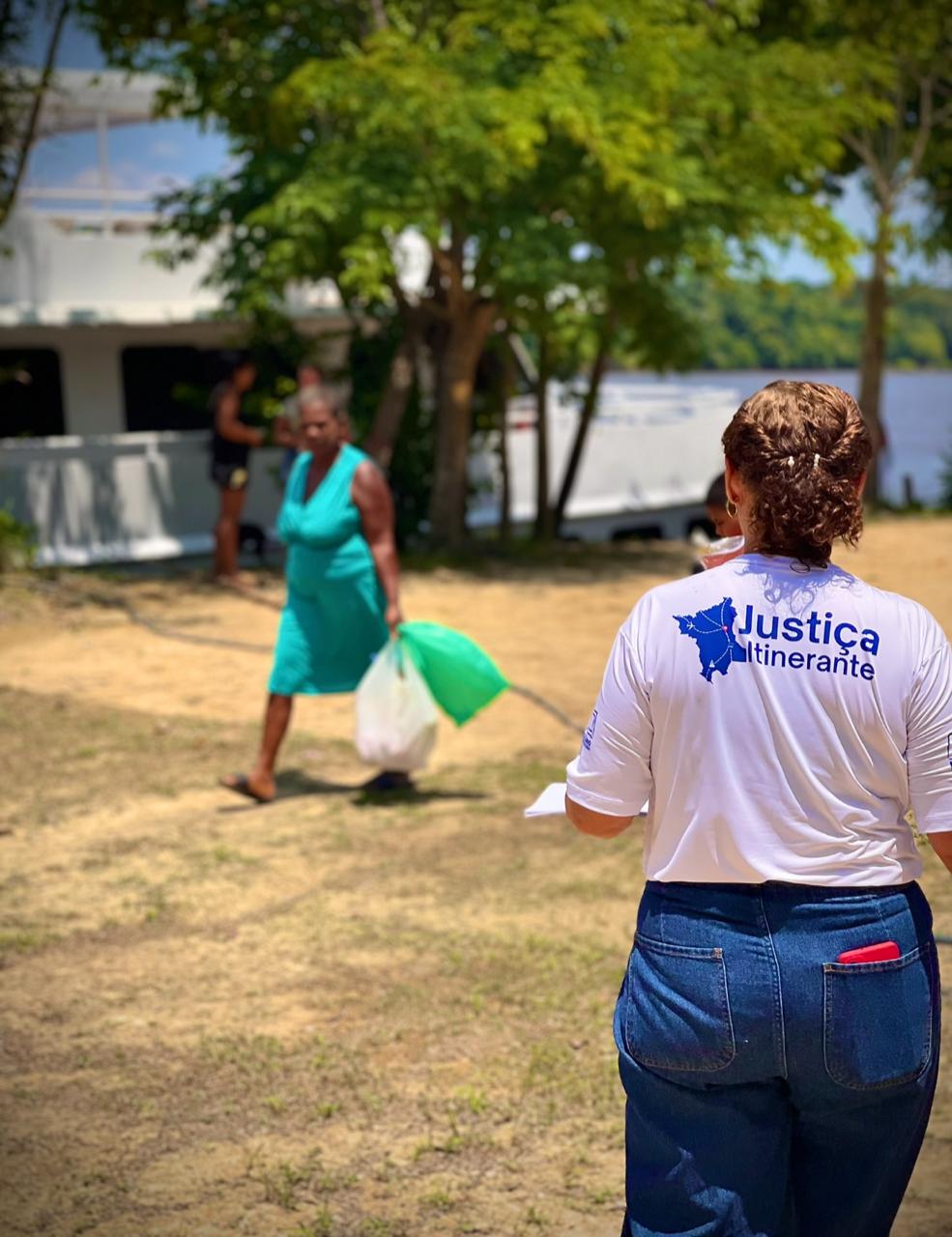 foto colorida de uma servidora do TJRR de costa. Em sua blusa branca contem Justiça itinerante