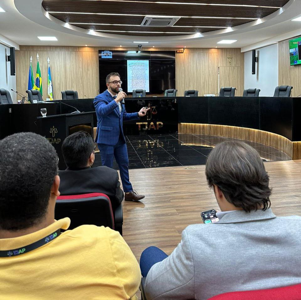 FOTO COLORIDA DENTRO DO TRIBUNAL DE JUSTIÇA DO AMAPA DO juiz auxiliar da presidência do Poder Judiciário de Roraima, Esdras Silva Pinto falando ao microfone em pé 