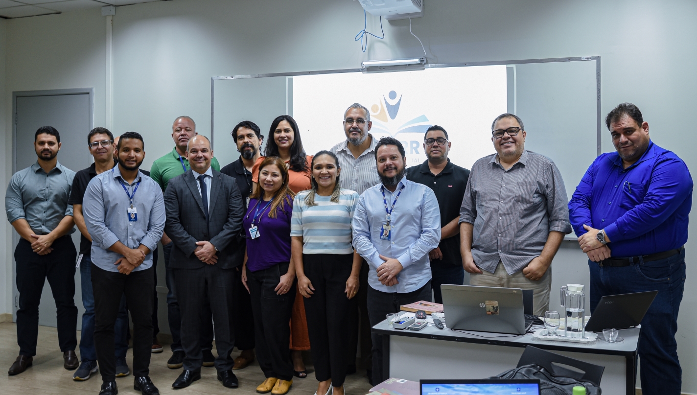 foto colorida da turma de mestrado pousando para a fotografia. Todos eles estão reunidos enfrente a lousa branca