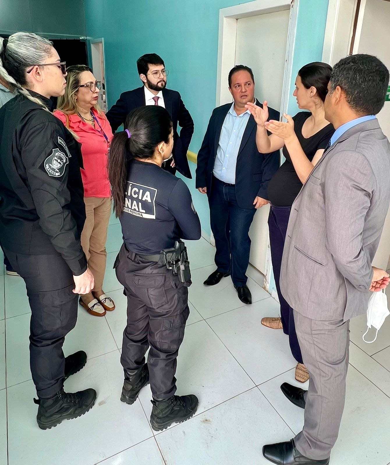 foto colorida com o  juiz Daniel Damasceno Amorim Douglas juntamebte com os inegrantes do sistema penal em um corredor da parte interna do local